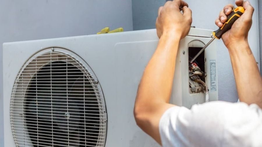 HVAC tech working on a broken heat pump unit