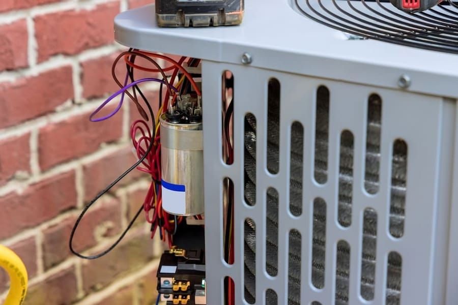 Air conditioning service in Madison and Greater Wisconsin with technician inspecting cooling system.