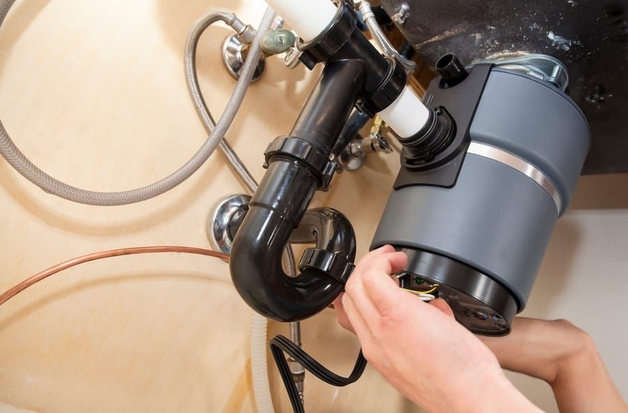 Garbage disposal repair and replacement in Madison and Greater Wisconsin under kitchen sink.