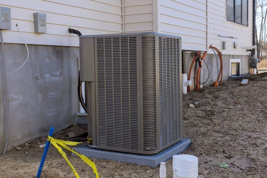 HVAC condenser unit installation outside home in Madison WI for residential heating and cooling services.