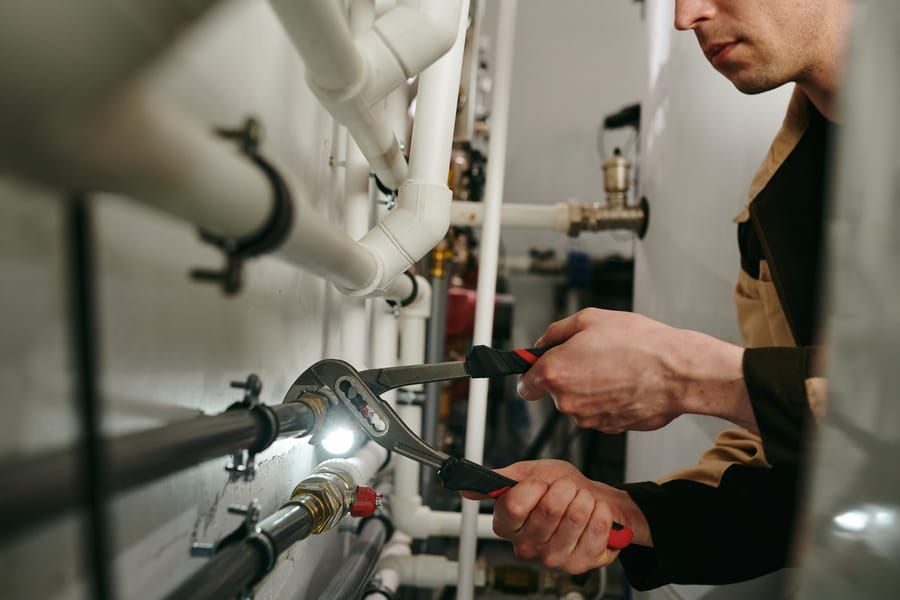 Commercial Plumbing Services, technician working on piping.